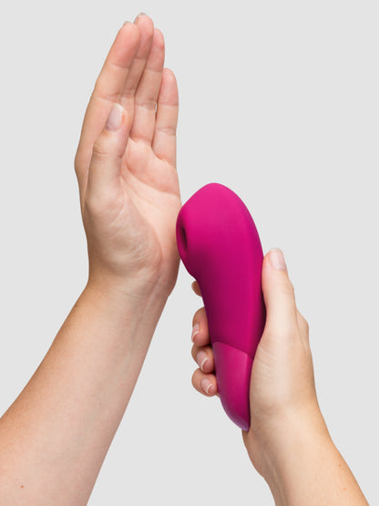 A person holds the hole of the Womanizer Enhance up against their palm. The vibrator looks like it has a relatively large air suction hole, but the tip does not look removable for easy cleaning. | Kinkly Shop