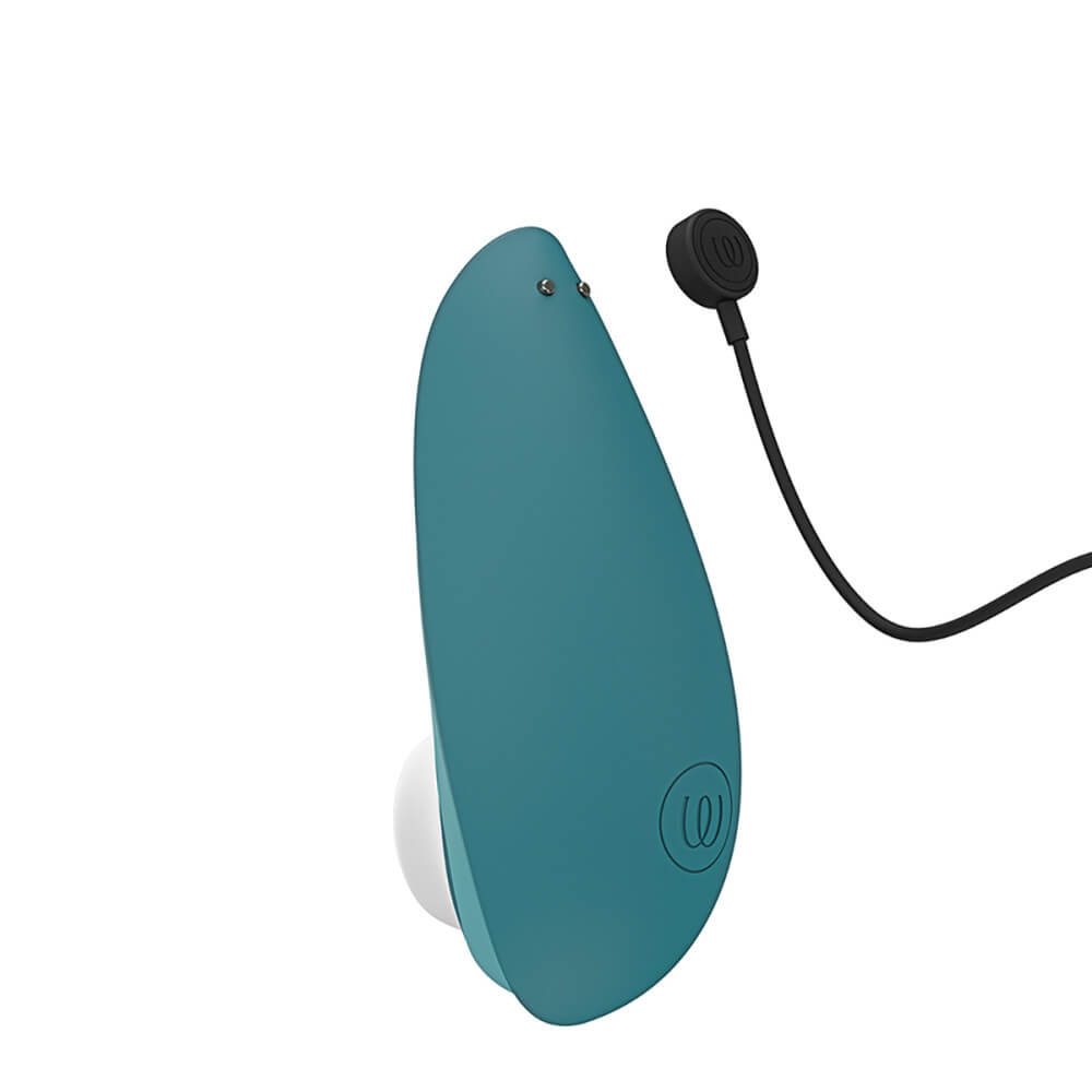 Close-up of the backside of the Womanizer Liberty 2 where the two magnetic charging ports are. The magnetic charging cable is shown right next to the connection ports. | Kinkly Shop