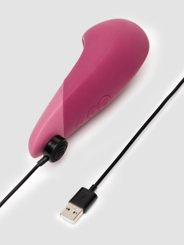 The Womanizer Vibe with the magnetic charging cable plugged into the base of the vibrator. | Kinkly Shop