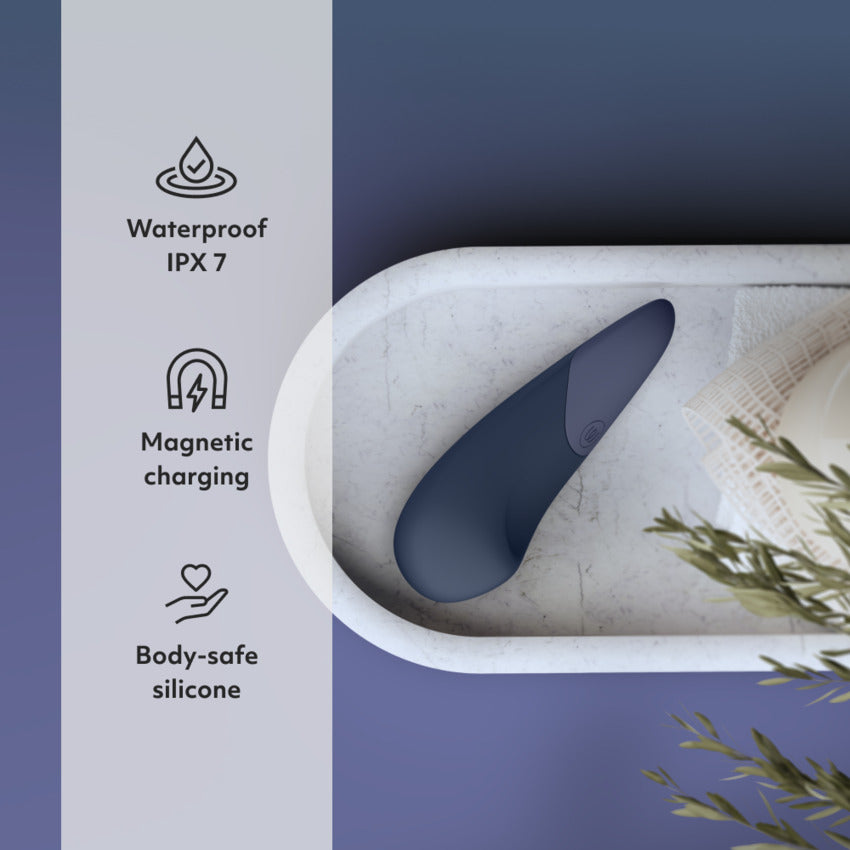 The Womanizer Vibe in Blue is laying on a tray. Text on the image reads: "Waterproof IPX7, Magnetic charging, Body-safe silicone" | Kinkly Shop