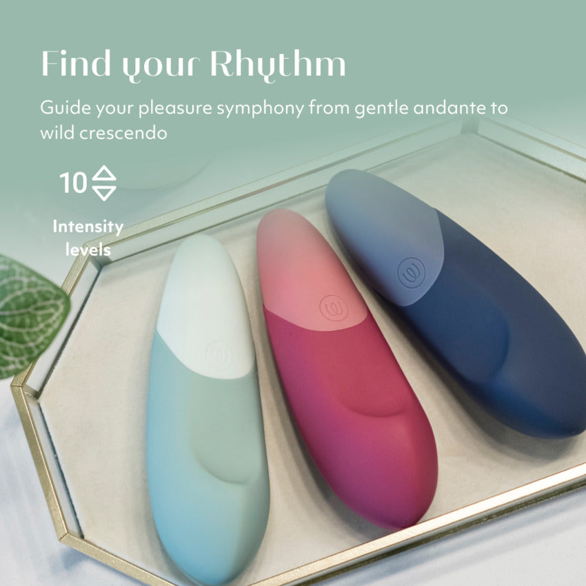 All three Womanizer Vibe colors are shown next to one another on a tray. Text on the image reads: "Find your rhythm. Guide your pleasure symphony from gentle andante to wild crescendo. 10 Intensity levels." | Kinkly Shop