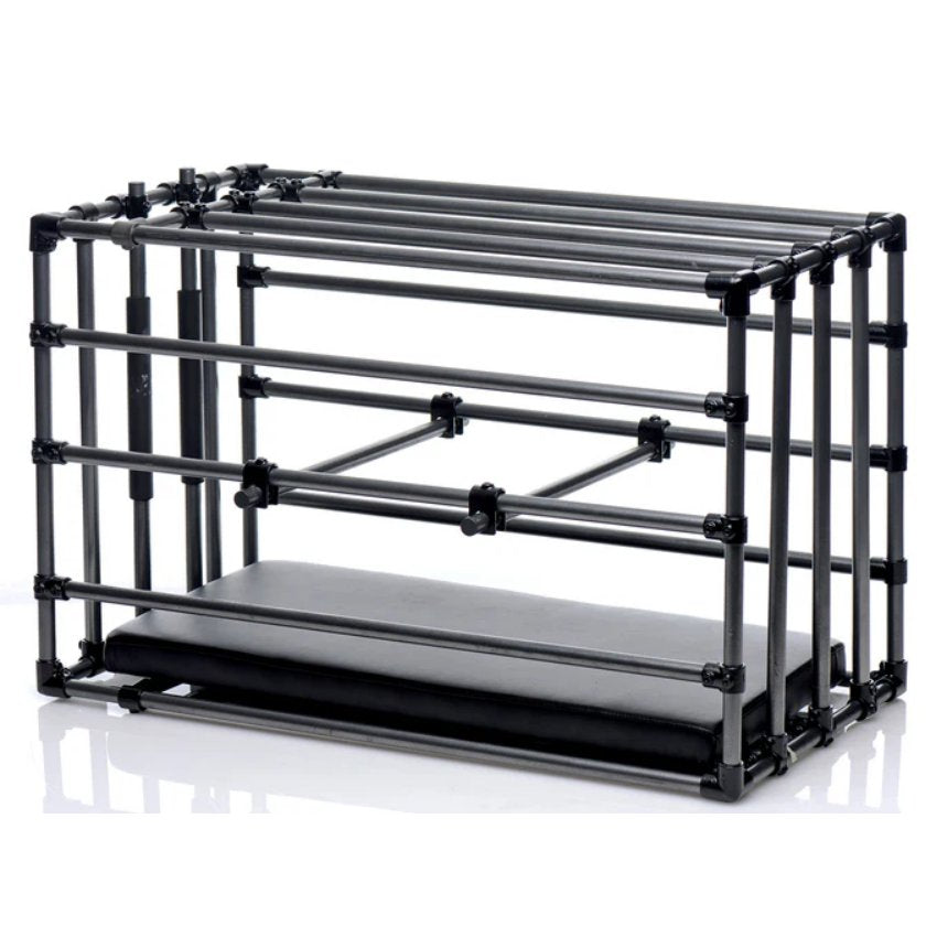 The XR Brands Adjustable Puppy Cage in front of a plain white background with the padded board inside and the two positional bars shown mid-way through the center of the cage. | Kinkly Shop
