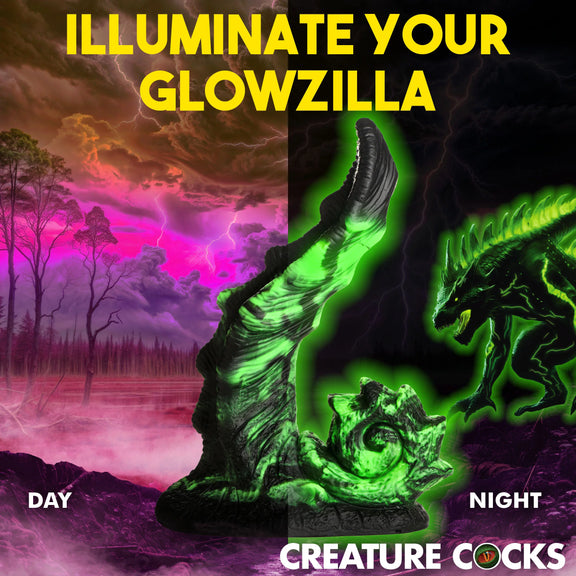 Two images of the Creature Cocks Glowzilla shown side by side. In one, it's daylight, and in the other, it's night. The dildo glows in the dark in the night version, but both versions look relatively the same in black and green coloration. | Kinkly Shop