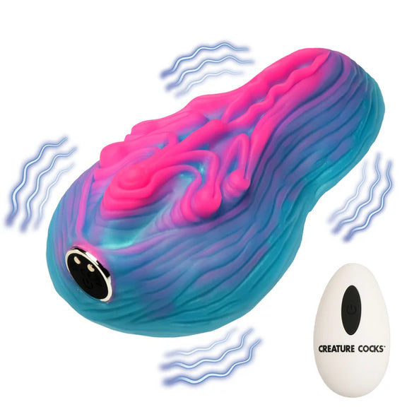 The Creature Cocks Vulvaron Remote-Control Vibrating Grinder shown next to the remote control. Illustrations are shown next to the toy's surface, showcasing how the toy vibrates. | Kinkly Shop