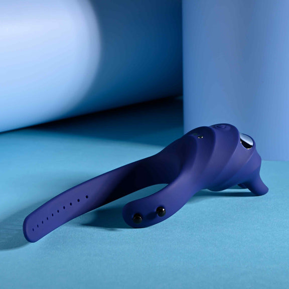 The Zero Tolerance Adjustable Fun Ring laying flat on the ground with the ring entirely unfastened. The cock ring has an adjustable loop like a belt loop. | Kinkly Shop
