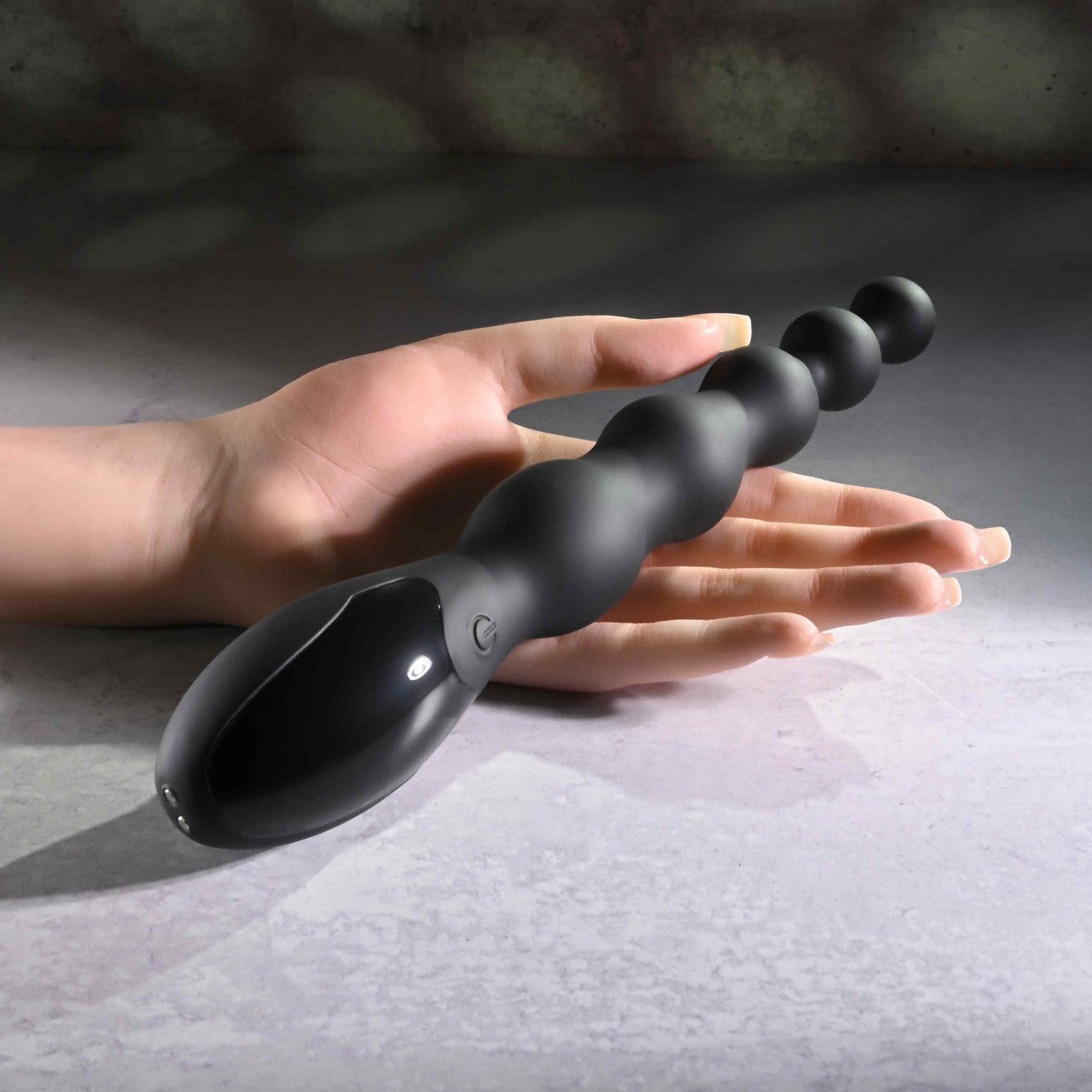 The Zero Tolerance Backdoor Baton rests on top of an open hand. The vibrator is much longer than the open palm. | Kinkly Shop