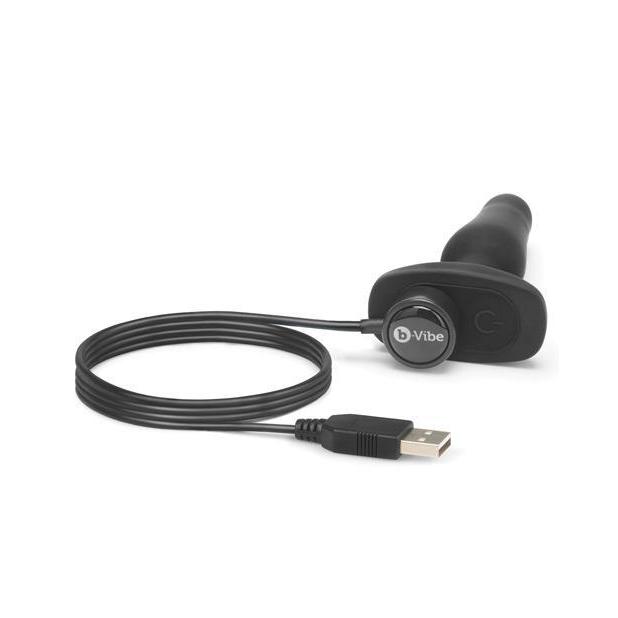 Close up of the base of the b-Vibe Remote Novice Plug with the magnetic charging cable placed on the magnetic charging port at the base. | Kinkly Shop
