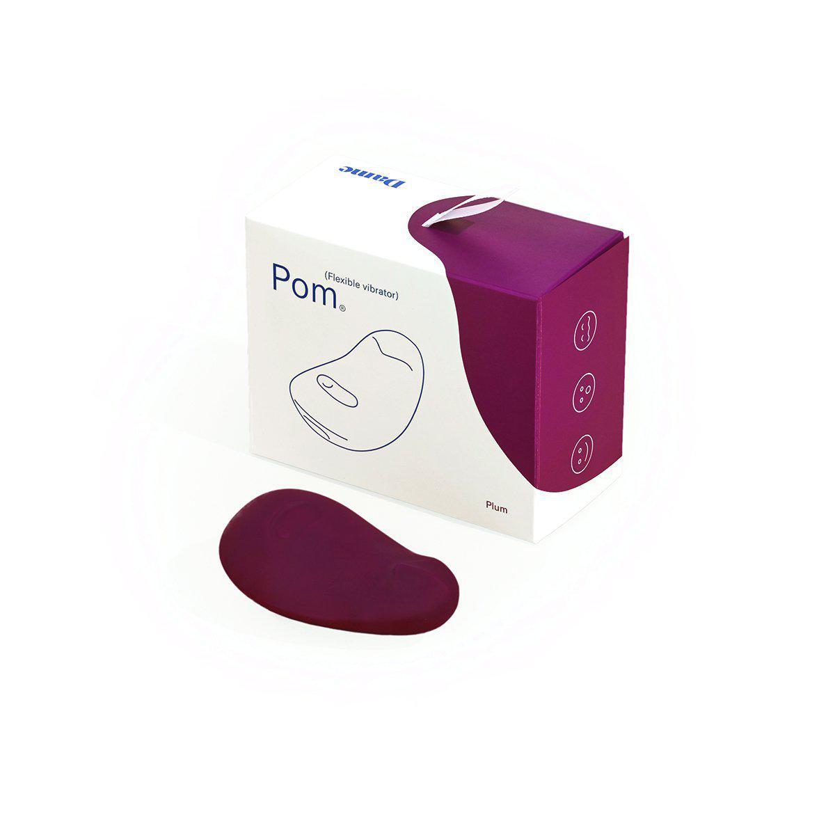 The Dame Pom sitting in front of its packaging. | Kinkly Shop