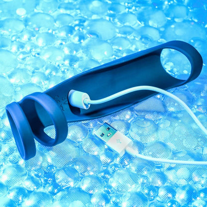 The magnetic charging cable is connected to the charging port of the Gender X Rocketeer. The port is located within the underside/chamber of the Gender X Rocketeer that would usually rest against the top of the penis while the Rocketeer is being worn. | Kinkly Shop
