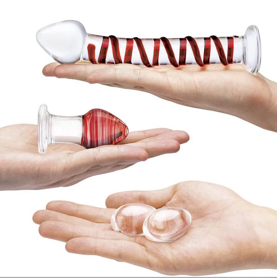 Three hands are all splayed out flat and holding various pieces of the 4-piece Glas Double Penetration Kit. | Kinkly Shop