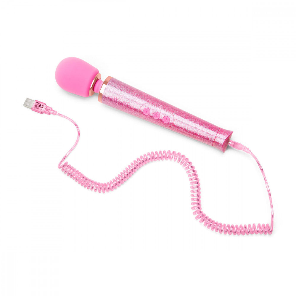 The Le Wand All that Glimmers Wand Massager laying out on a flat surface. Its color-matching charging cord is attached at the base of the wand. The cord includes spirals in a 90's style as well as a glitter coating that matches the wand massager. | Kinkly Shop