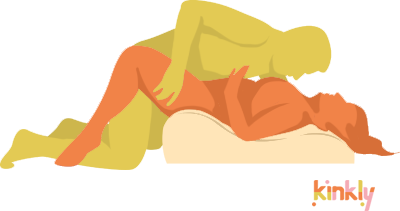 Illustration shows the Liberator Hipster in use. The receiving partner lays on top of the Hipster with their hips on the tallest edge of the Hipster. The penetrating partner leans over the receiving partner to penetrate. | Kinkly Shop