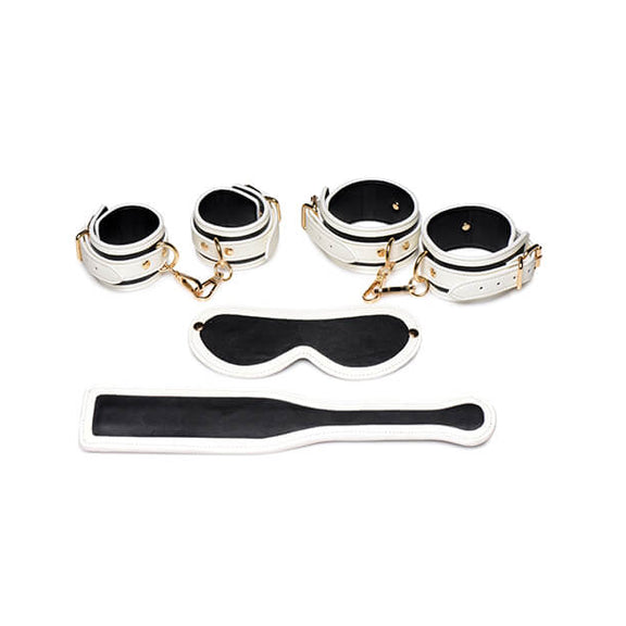Master Series Kink in the Dark Set shown during the daylight. All of the items look black with white trim lining them. The image shows all four cuffs, the blindfold, and the paddle laid flat. | Kinkly Shop