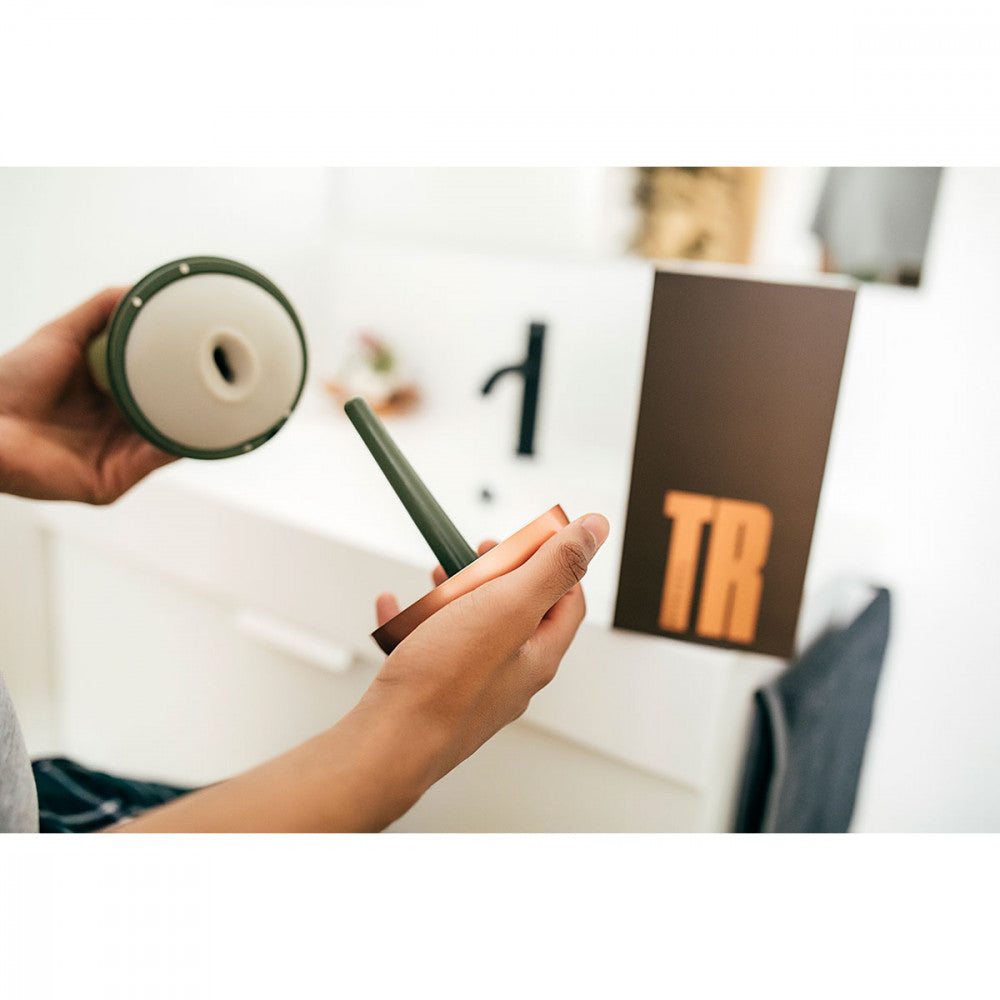 A person holds the MyHixel TR premature ejaculation sex toy in one hand and the cap for the MyHixel TR orgasm control penis stroker in the other hand | Kinkly Shop
