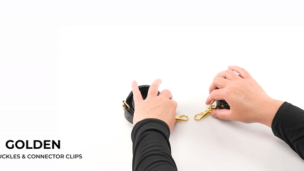 GIF of the Sportsheets Cuffs and Blindfold Set. The cuffs are sitting on a white table with two hands in the frame. The two hands fasten the two, attached, golden connector clips to each other to instantly bind the two cuffs to one another. The text on the GIF reads "Golden buckles and connector clips." | Kinkly Shop