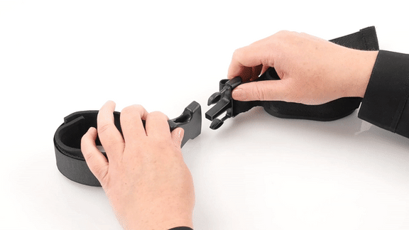 GIF shows the structure of the G-Spot Link Positionary Cuffs. The person puts their wrist into a cuff and fastens it onto the wrist with Velcro. They then tug on the cuff to show the durability. They then snap together the two cuffs with the snap clip in the middle of the two cuffs. The text says "Reduces Leg Fatigue and Lower Back Pressure." | Kinkly Shop