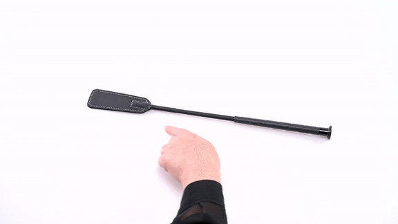 GIF of the Sportsheets Romantic Sting Riding Crop. The GIF shows a person picking up the riding crop and spanking their palm with the crop. The text says "Perfect for Up Close & Personal Play". | Kinkly Shop