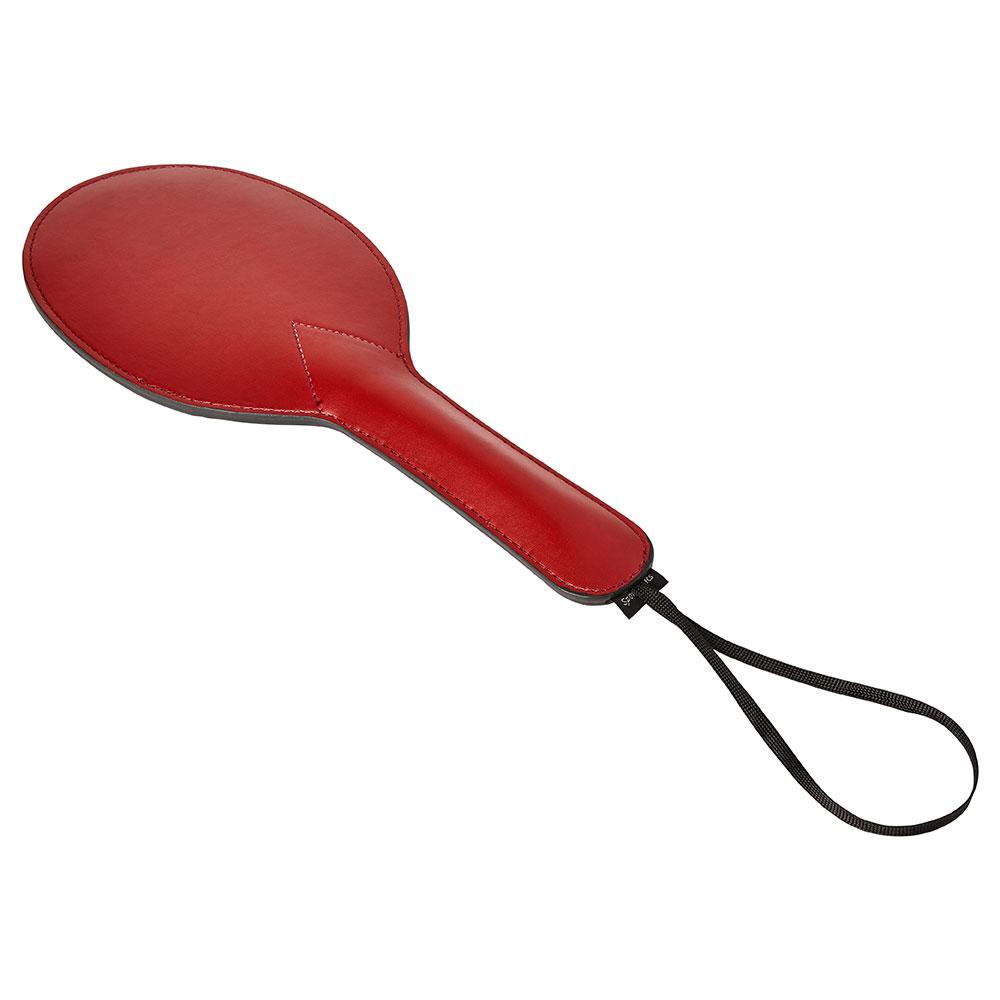 Sportsheets Saffron Ping Pong Paddle lays on a flat, white surface. This angle showcases the thickened diameter of the handle for easier handling as well as the simple loop at the base of the handle for more secure and easier handling. | Kinkly Shop