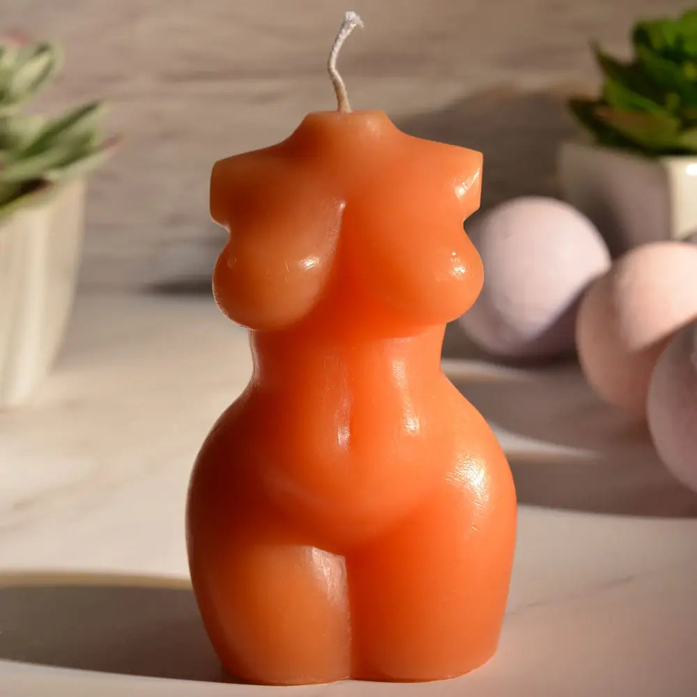 The Sportsheets Torso 1 Wax Play Candle sitting on a marbled counter with mood lighting. | Kinkly Shop