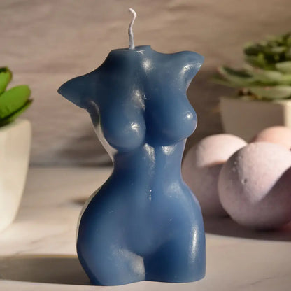 The Sportsheets Torso 3 Wax Play Candle sitting out on a marbled countertop with harsh, afternoon sun lighting that leaves parts of the calendar in dark shadows. | Kinkly Shop