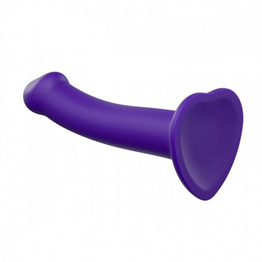 The Strap-on-Me Bendable Dual-Density Dildo faces away from camera to show the heart-shaped flared base. You can see that underneath the dildo base is slightly concave. | Kinkly Shop