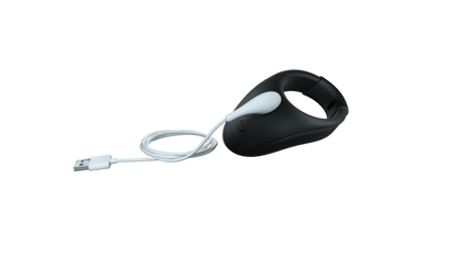 The We-Vibe Bond with the charging cable hanging off the charging port to show how the We-Vibe Bond charges. It's a magnetic design that "snaps in" to the proper spot for charging. | Kinkly Shop