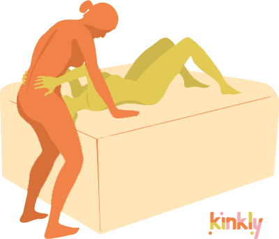 The giving partner is laying out flat, on their back, on an elevated surface like a bed. The giving partner's head is hanging off the edge of the bed. The receiving partner has their thighs spread and is straddling the giver's face. 