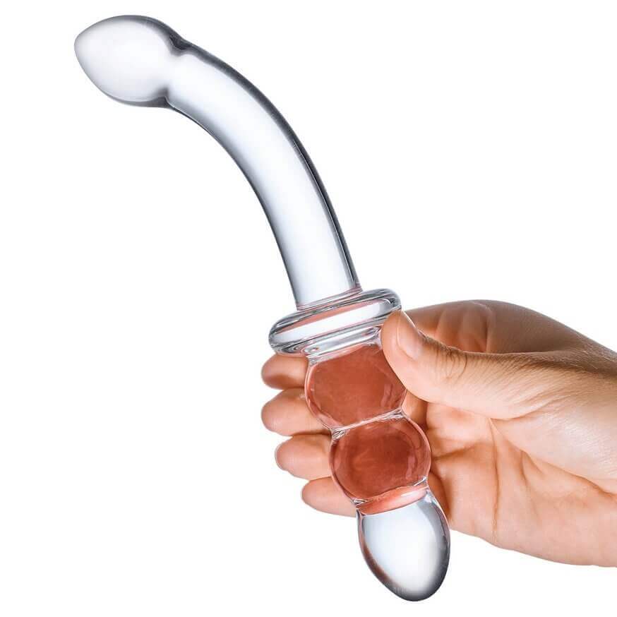 A hand holds the "handle" area of the 8" Glass Ribbed G-Spot dildo. The handle is long enough for the person's hand to easily grip the base of the dildo. The g-spot tip of the dildo protrudes far away from the dildo in a drastic curve. | Kinkly Shop