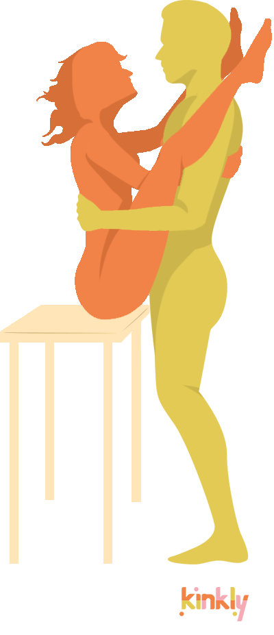 Erotic V Sex Position. The receiving partner sits on the edge of a sturdy table that's at the perfect height for penetration. The penetrating partner stands next to the table with the receiving partner's ankles on their shoulders.