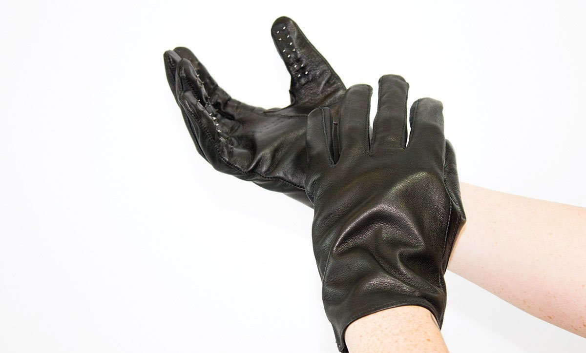 Image of vampire gloves. Shows a person's two hands and forearms as they wear black vampire gloves. The gloves have obvious spikes pointing out of them.