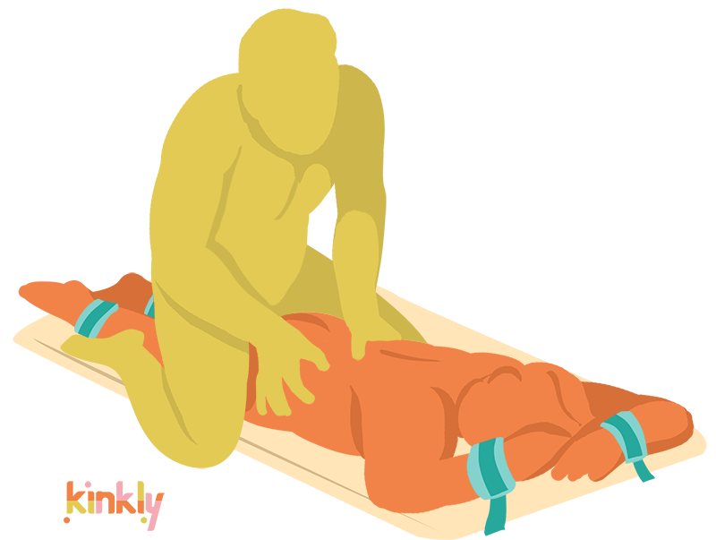 Restrained Rub Down Sex Position. The receiving partner is laying flat, face down, on top of the Liberator Bondi with their wrists and ankles bound to the Bondi. The penetrating partner is straddling the receiver's upper thighs to penetrate. 