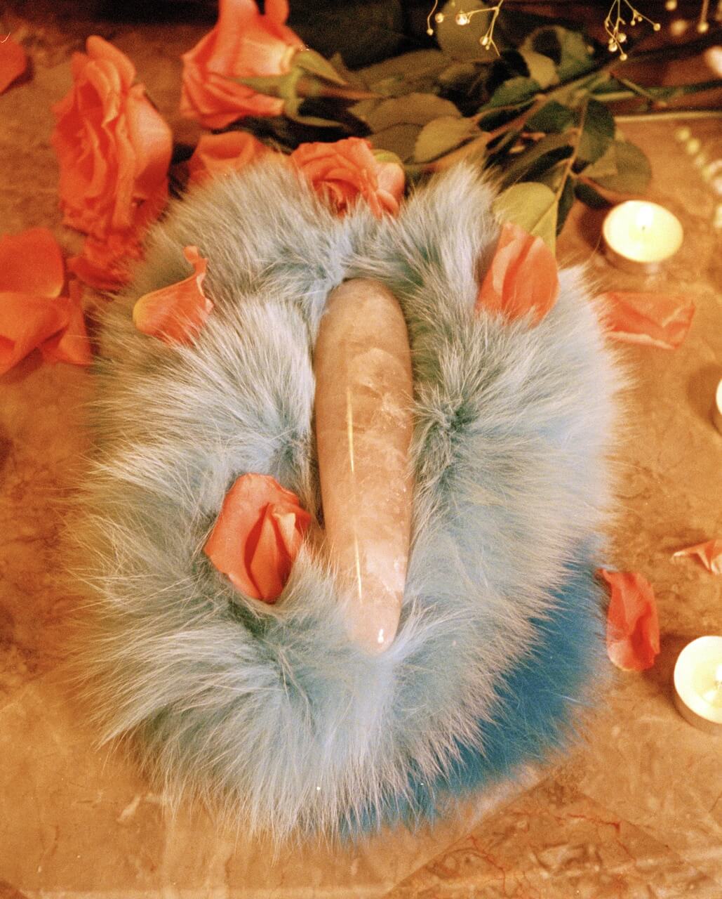 pink crystal wand dildo on fur with rose petals